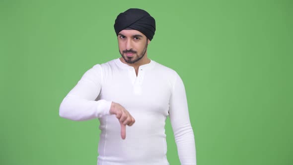 Young Serious Bearded Indian Man Giving Thumbs Down