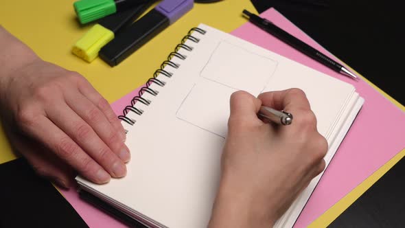 Woman Hand Drawing Storyboard Boards in a Sketchbook. Close Up