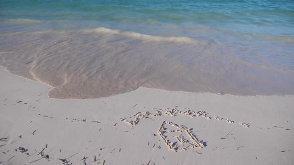 Drawing of House and Inscription Dream on Sand Washed Away By the Ocean Wave