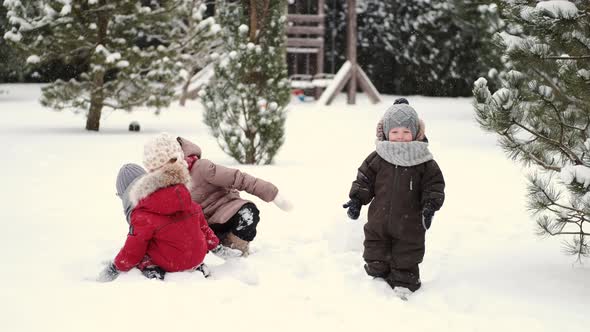 Children i Building a Snowman on a Winter Day at Backyard