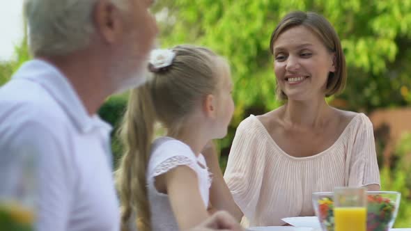 Family Having Lunch in Fresh Air Husband Bringing Roast Chicken and Hugging Wife