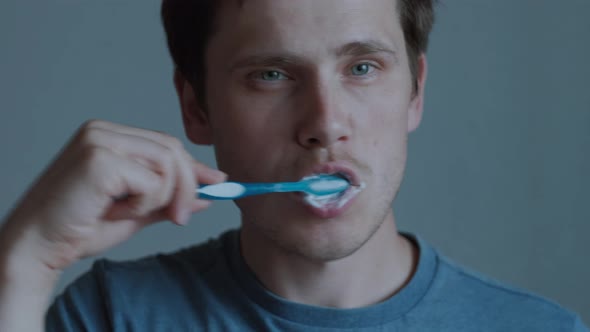 A Young Guy is Brushing His Teeth