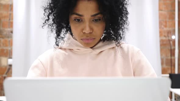 Excited AfroAmerican Woman Celebrating Success While Working on Laptop Sitting on Couch