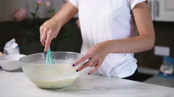 Unrecognizable Woman Prepares Dough Mixing Ingredients in the the Bowl Using Whisk