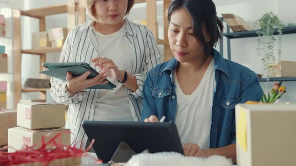 Asia businesswomen meeting check product purchase order on stock and save to tablet computer work.