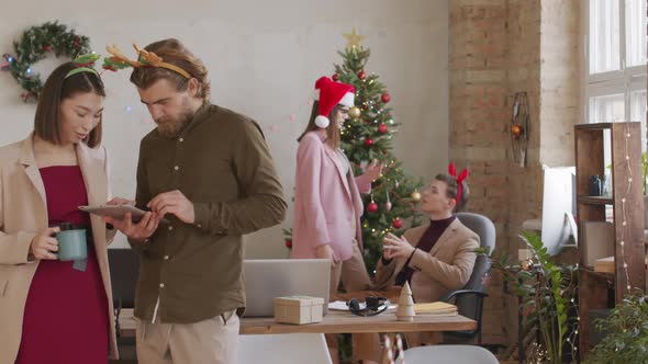 Portrait of Coworkers in Festive Headbands Posing in Office on Christmas