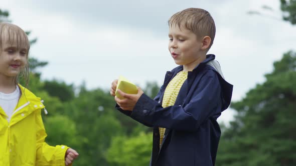 Siblings Playing with Paper Boats