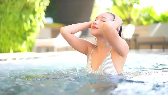 Young asian woman enjoy around outdoor swimming pool for leisure