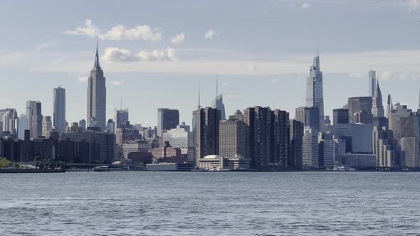 Empire State Building and surrounding city skyline from over East River.