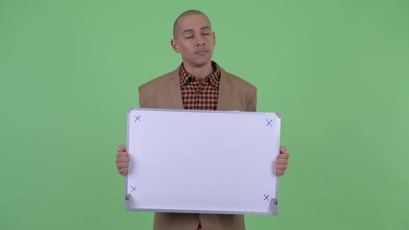 Stressed Bald Multi Ethnic Businessman Thinking and Talking While Holding White Board