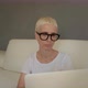 Blond woman with blue eyes on sofa with laptop - VideoHive Item for Sale