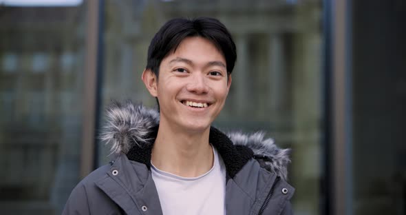 Young happy Chinese man slow motion portrait laughing and looking at camera