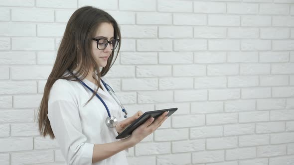 Young girl doctor with tablet.