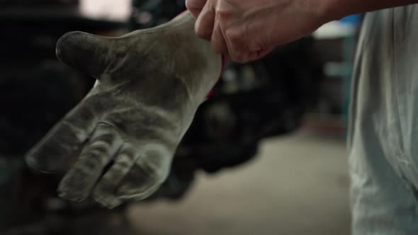 Auto mechanic wearing leather gloves in mechanics garage, Repair and Maintenance service