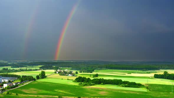 Aerial view of rainbow over green fields after a storm