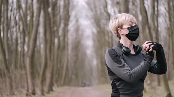 A Middle-aged Woman in a Mask Is Doing Morning Exercise Outside