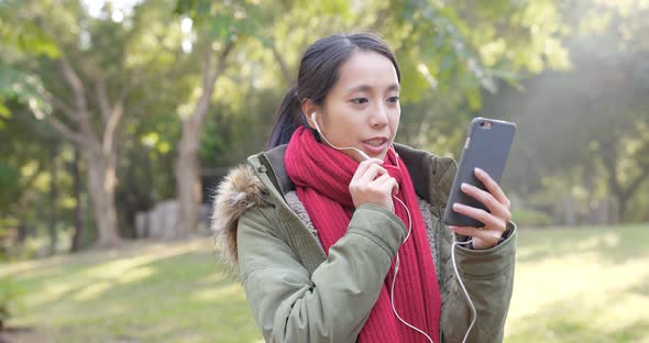 Woman making live stream on smart phone in city park