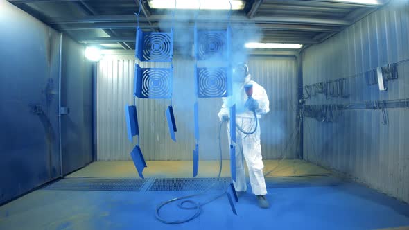 Factory Specialist in Safety Wear Is Spraypainting Metal Pieces