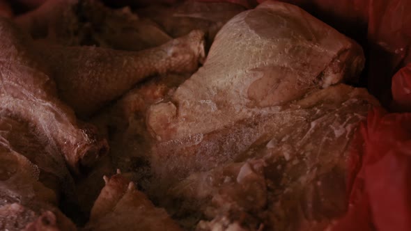 Closeup View of Hands in Gloves Packing Chicken Legs From a Box Into Individual Plastic Bags