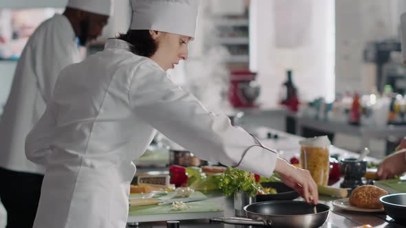 Young Woman Cooking Food Recipe with Garlic Clove on Kitchen Stove