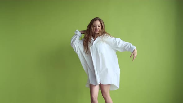 Girl With Long Hair Dancing On Background Of Light Green Wall