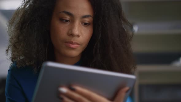 Attractive Businesswoman Surfing Web Using Digital Tablet in Remote Workplace