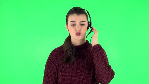 Young Girl Talking on Headphones, Call Center. Green Screen