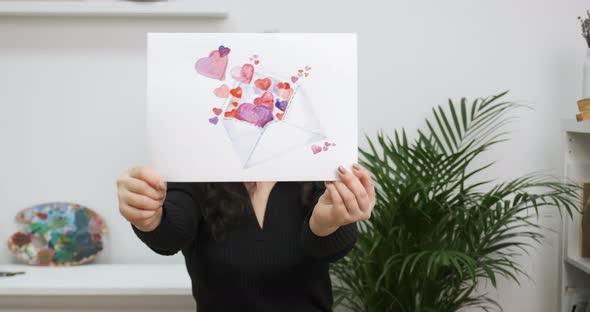 Cheerful Girl Celebrates Saint Valentine's Day Showing Picture with Hearts