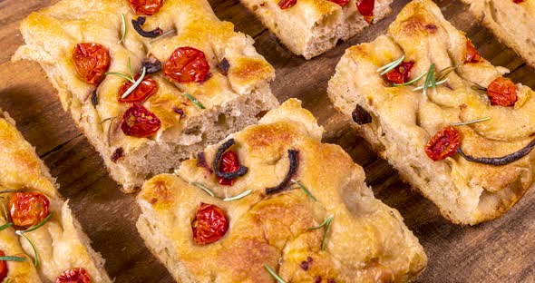 Homemade italian flat bread - Focaccia contorta. With olives, olive oil, rosemary, tomatoes. Traditi
