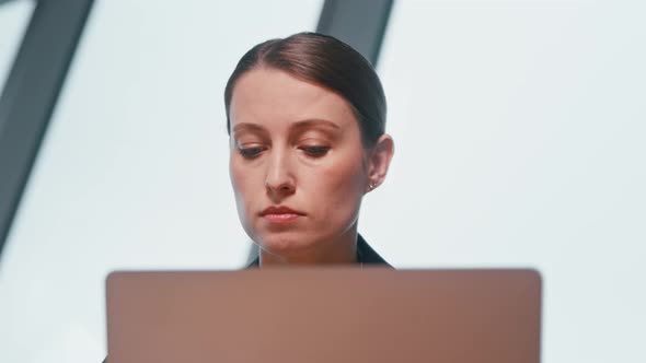 Young woman surfing the internet using a laptop close-up. Face of young woman with laptop