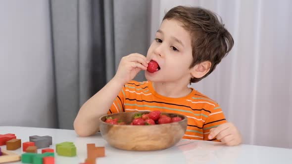 Smiling Boy at Breakfast Eating Fruit Strawberries