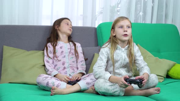 Little Gamers Playing with Game Pads on Sofa