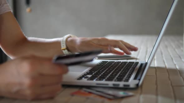 Close Up Of Woman Shopping Online Using Laptop With Credit Card