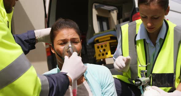 Patient receiving oxygen mask from ambulance team