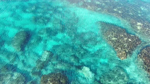 Crystal Clear Turquoise Waves Rolling Over Rocks at Ocean Bottom. Top View of Calm Waters of