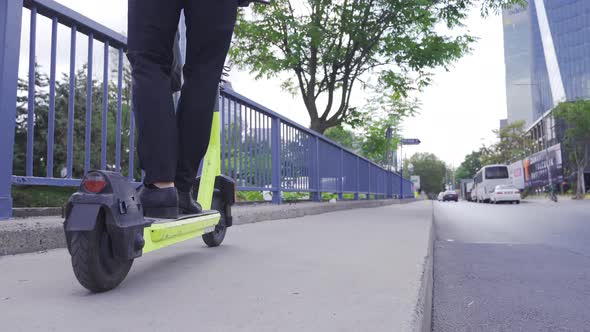 Man In Formal Suit Riding Electric Scooter In The City.