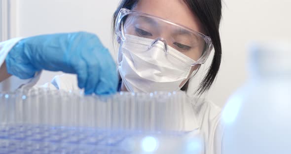 Scientist putting drops of chemical into test tube 