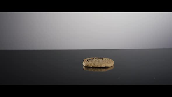 Falling cookies from above onto a reflective surface 