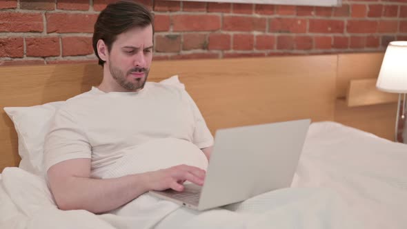 Casual Young Man with Laptop Having Coughing in Bed