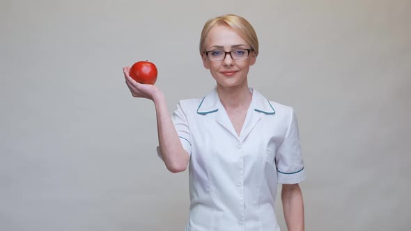 Nutritionist Doctor Healthy Lifestyle Concept - Holding Organic Red Apple and Alarm Clock