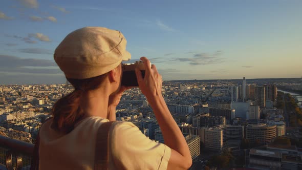 Young girl taking photo of the city