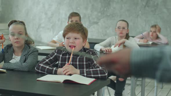 Group of School Kids in Class Together, Listening To the Teacher