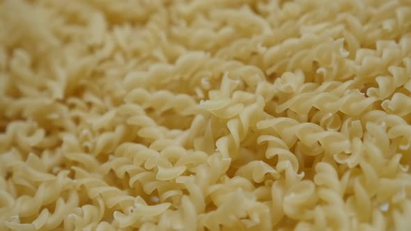 Slow motion  Italian food Girandole corkscrew shaped pasta pile on table  1920X1080 HD footage - Spi