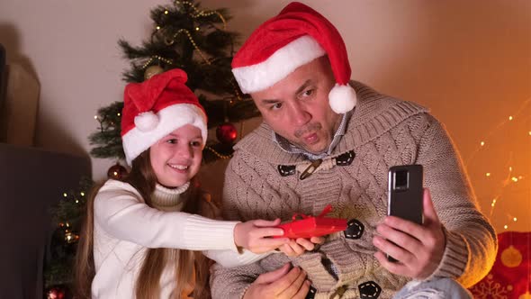 Happy Family Dad and Daughter at Home During Christmas Eve Day Enjoy a Video Phone Call Show Gift