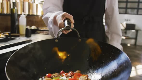 Chef cooking vegetables with fire