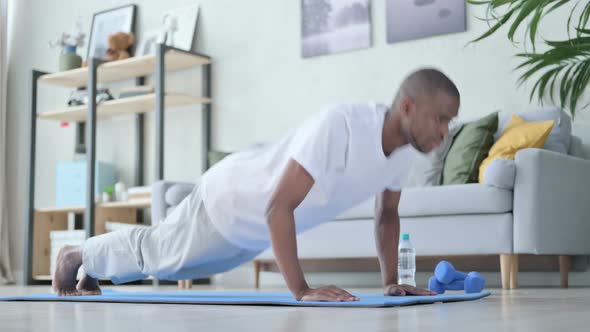 Young African Man Doing Pushups on Yoga Mat at Home