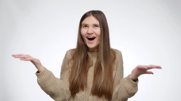 Happy Cheering Girl After Winning in Lottery Looking Up and Raising Hands Over White Studio