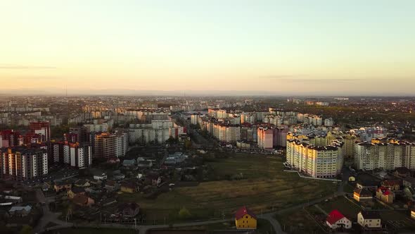 Aerial view of high residential apartment buildings and private houses in suburbun area at sunset 