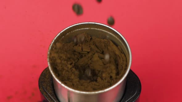 Coffee Beans Grind in Electric Mill Into Powder, Red Background. Morning Concept