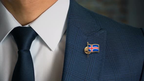 Businessman Walking Towards Camera With Country Flag Pin Iceland